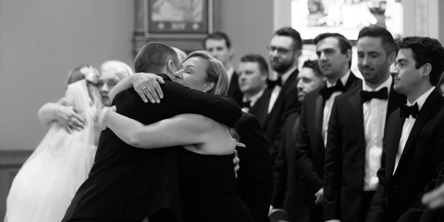 Photo of a family members hugging at wedding. Photography by C.Mae Photography.
