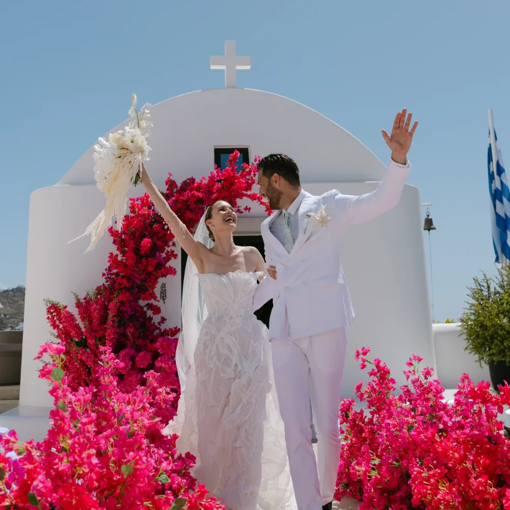 A couple getting married and surrounded by beautiful flower. Photo by C.Mae Photography.
